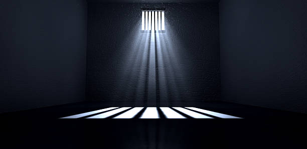 Sunshine Shining In Prison Cell Window An old jail cell interior with barred up window with light rays penetrating through it reflecting the image on the floor prison stock pictures, royalty-free photos & images