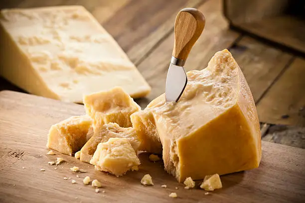 Parmesan Cheese Portion with Crumbs on Cutting Board