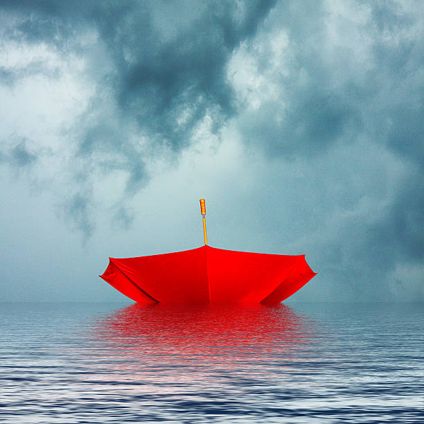 istock Red Umbrella Upside Down Floating in Water 188143284
