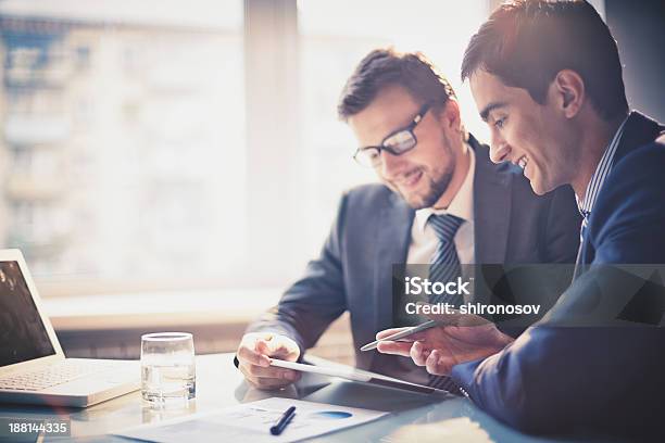 Two Businessmen Talking While Looking At Notes Stock Photo - Download Image Now - Business Meeting, Meeting, Business