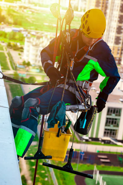 istock Industrial mountaineering worker in uniform washing exterior glazing 1881445310