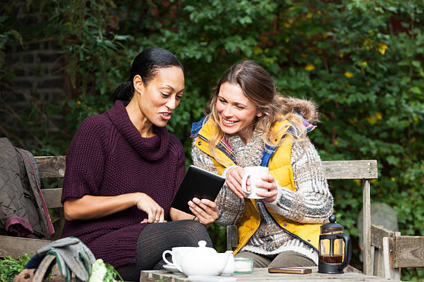 istock Two Women In Garden Having Coffee Looking At Digital Tablet 188147553