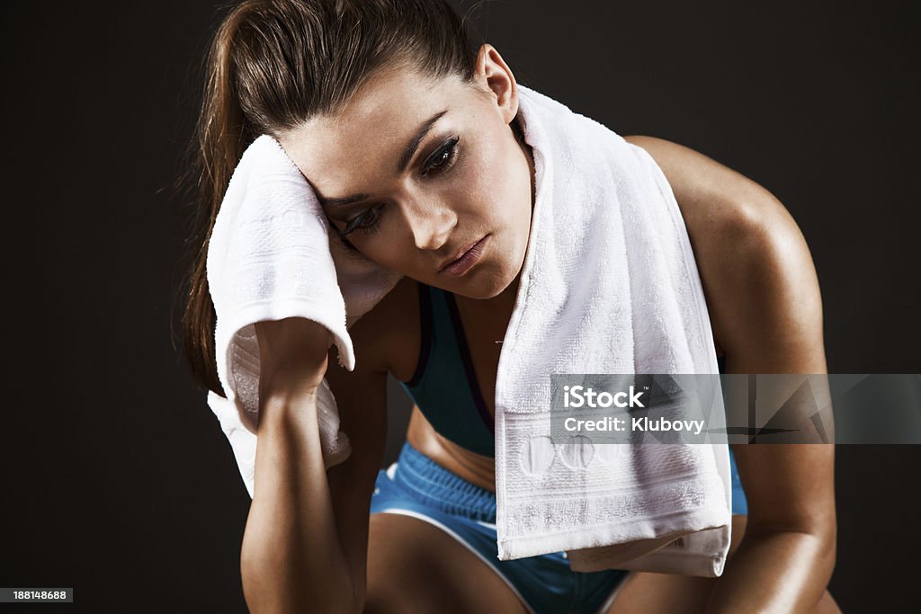 Tired woman resting after workout Portrait of a tired young woman resting after workout. Adult Stock Photo