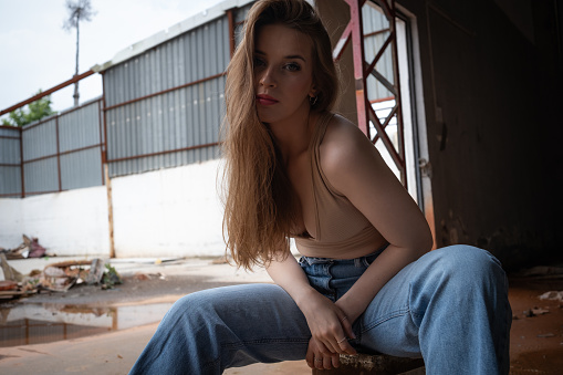 Portrait of a brunette and beautiful young woman in an abandoned place.