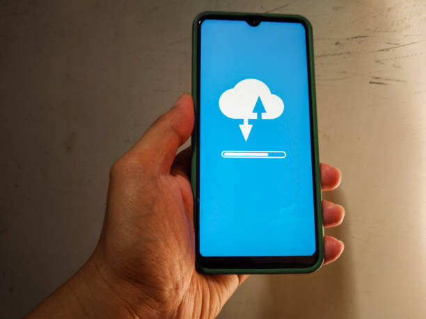 istock Cloud uploading and downloading from mobile phone for file sharing and collaboration. Cloud computing concept. 1881514309