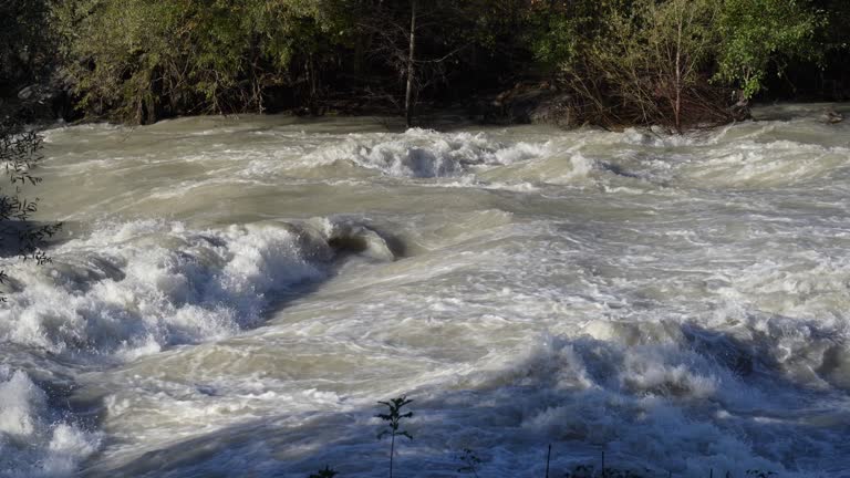 The Serio river swollen after heavy rainfall and floodwater crashing through valley. The water flows fast from the high valley to the plain. River in Province of Bergamo, northern Italy