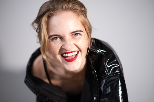Portrait of a young beautiful woman wearing a shiny leather jacket.