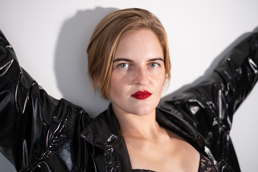 Portrait of a young beautiful woman wearing a shiny leather jacket.
