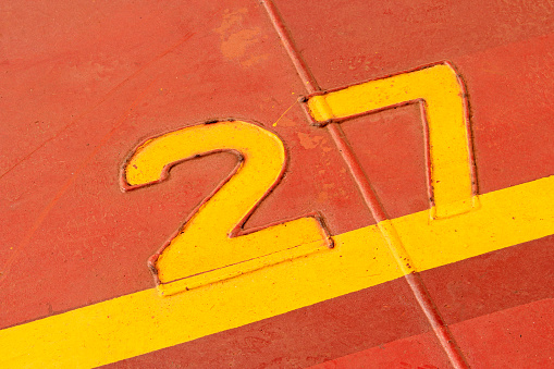 Numbers and lines in yellow brown sheet metal, closeup of photo