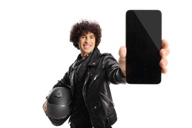 Biker in a black leather jacket holding a helmet and a smartphone