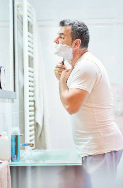 hombre afeitando barba con navaja de afeitar en el baño - shaving equipment wash bowl bathroom razor fotografías e imágenes de stock