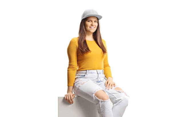 istock Young gen z female sitting on a white column and smiling at camera 1881667950