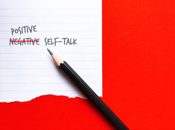 istock Pencil on red background with note NEGATIVE SELF-TALK changed to POSITIVE, concept of overcome negativity inner voice critics which impact confidence, change them to positive optimistic ones 1881684070