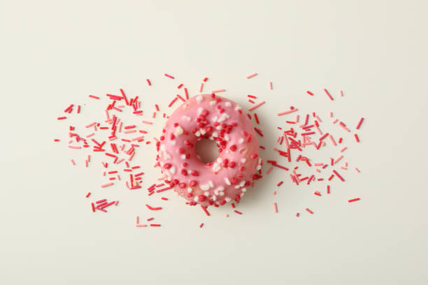istock Donut with pink glaze and sprinkles on white background, top view 1881736169