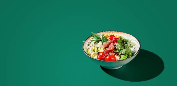 banner of asian poke bowl with tuna, avocado, and edamame served in a bowl, against a green monochromatic background. modern minimalist presentation with copy space - 16318 imagens e fotografias de stock