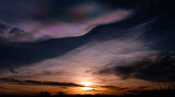 Beautiful Iridescent Pileus Cloud Over Sunset,Rare Natural of Sunset Sky of Fire Rainbows or Rainbow Clouds.Dark Cloud with Colourful optical Phenomenon sky in Winter Evening in UK