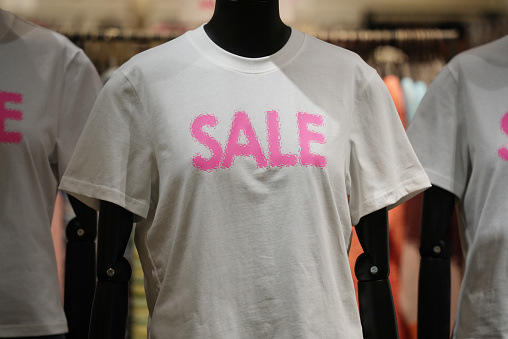Seasonal discount sign on shirt of a clothing store