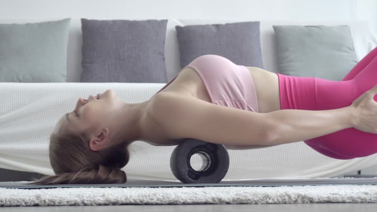 Asian woman exercise with foam roller.