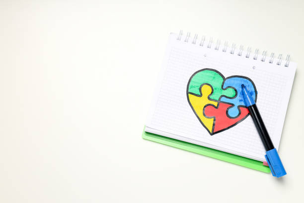 istock Notebook with drawn puzzle heart on white background, place for text. World autism day concept 1881770245