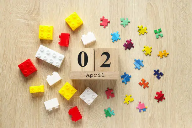 Multicolored puzzle pieces and legos on a light background. World autism day concept