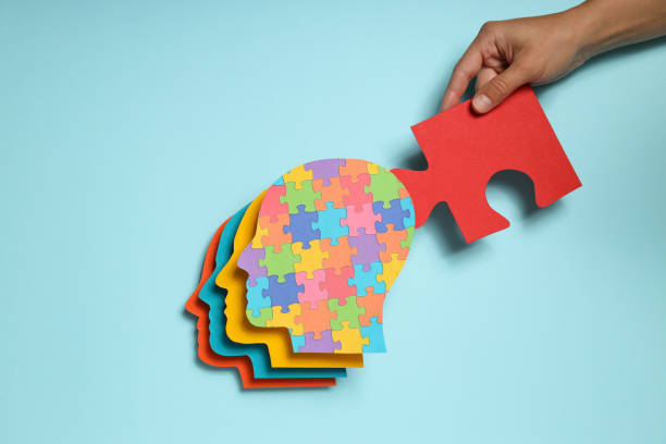 istock Colored heads and puzzle in hand on blue background, top view 1881772838
