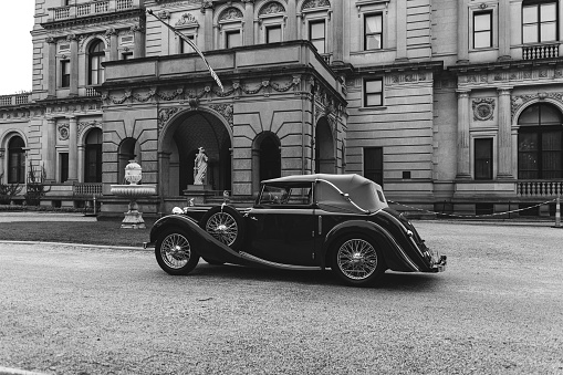 Newport, United States – October 06, 2023: A classic vintage car is parked in front of a historic building. Audrain Car Show