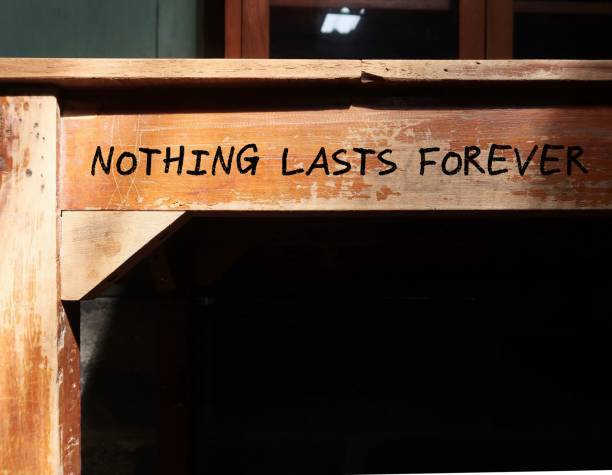istock Vintage school desk with black copy space shadow and handwritten text NOTHING LASTS FOREVER, means there is not a thing in this world that permanent, things today might not be there tomorrow, even our feelings will never lasts 1881793925
