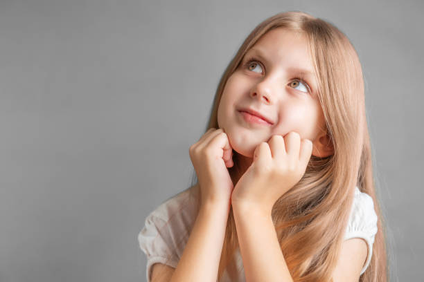 Portrait of positive cheerful girl cutely smiling Portrait of positive cheerful girl cutely smiling, girl with long blonde hair in white t-shirt cutely stock pictures, royalty-free photos & images