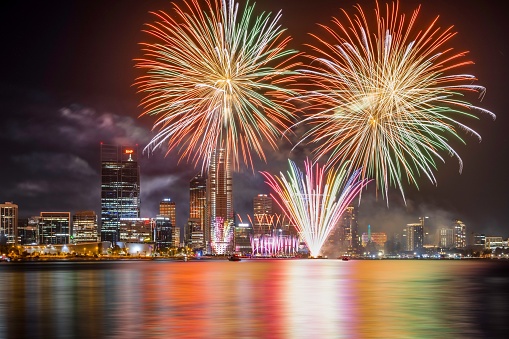 Perth, Australia – February 19, 2023: A dazzling display of vibrant fireworks erupting against the backdrop of a bustling city skyline at night