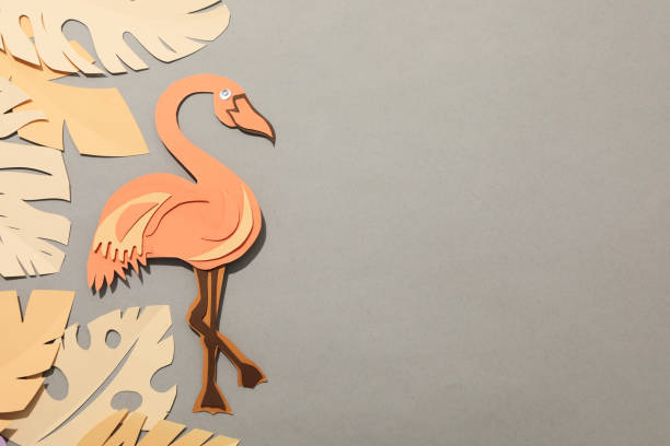 istock Paper peach tropical leaves on a gray background. With birds. 1881824497