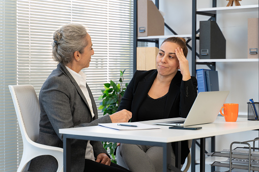 Senior female employee supports upset depressed female co-worker colleague