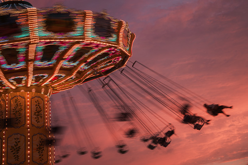 A group of people enjoying a thrilling ride in a ferris wheel with a scenic backdrop of sky and clouds