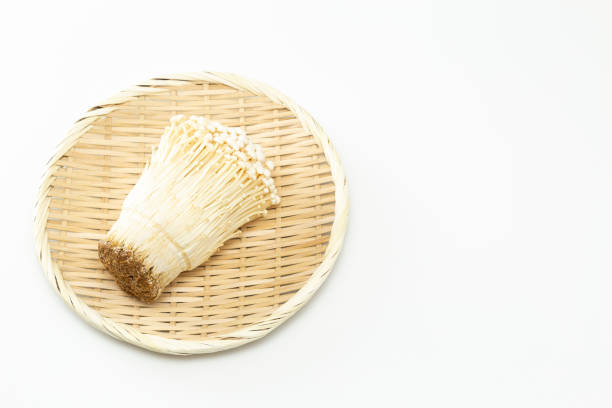 Enoki mushrooms on a white background.