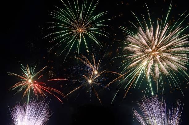 istock brightly colored fireworks being set in the dark sky over water 1881982106