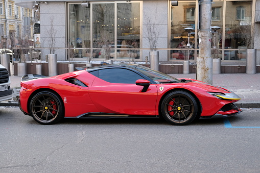 Kyiv, Ukraine - January 2023: new red Ferrari SF90 Stradale parked on street