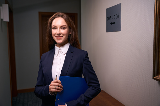 Business woman with crossed arms in front of a corporate office