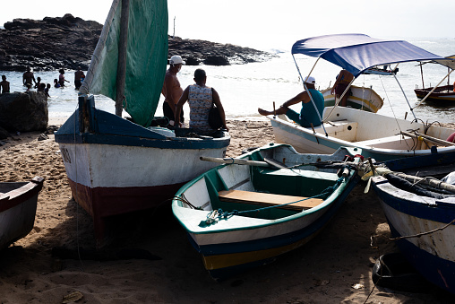 Salvador, Bahia, Brazil - January 30, 2022: Fishermen are seen on the Rio Vermelho beach next to boats in the city of Salvador, Bahia.