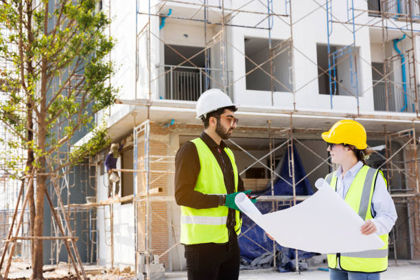 istock Engineers and Architect Caucasian looking at blueprint of building construction, planning the work in a professional. inspector is looking at steel structure and materials at construction site. 1882165913