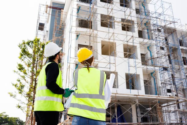 istock Engineers and Architect Caucasian looking at blueprint of building construction, planning the work in a professional. inspector is looking at steel structure and materials at construction site. 1882165916