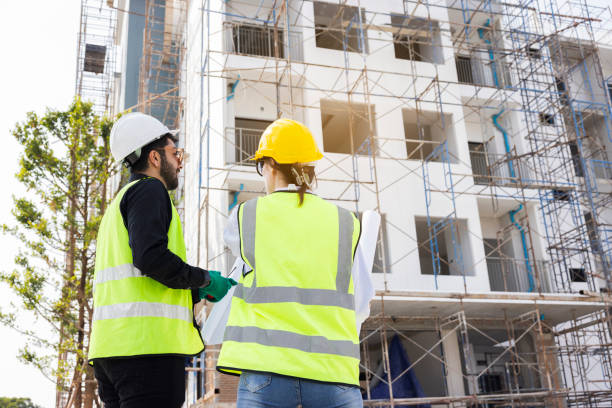 istock Engineers and Architect Caucasian looking at blueprint of building construction, planning the work in a professional. inspector is looking at steel structure and materials at construction site. 1882165918