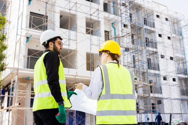 istock Engineers and Architect Caucasian looking at blueprint of building construction, planning the work in a professional. inspector is looking at steel structure and materials at construction site. 1882165921