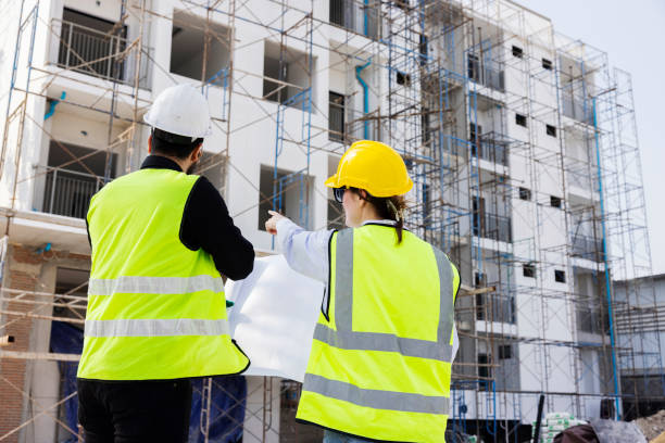 istock Engineers and Architect Caucasian looking at blueprint of building construction, planning the work in a professional. inspector is looking at steel structure and materials at construction site. 1882165924