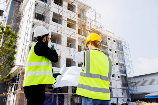 istock Engineers and Architect Caucasian looking at blueprint of building construction, planning the work in a professional. inspector is looking at steel structure and materials at construction site. 1882165925