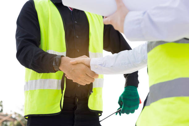 istock Engineers and Architect Caucasian looking at blueprint of building construction, planning the work in a professional. inspector is looking at steel structure and materials at construction site. 1882166437