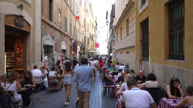 Rome, Italy - 5 September 2023. Sightseeing tourists and citizens walking on ancient Roman streets in city center. Restaurants and cafe with traditional cuisine
