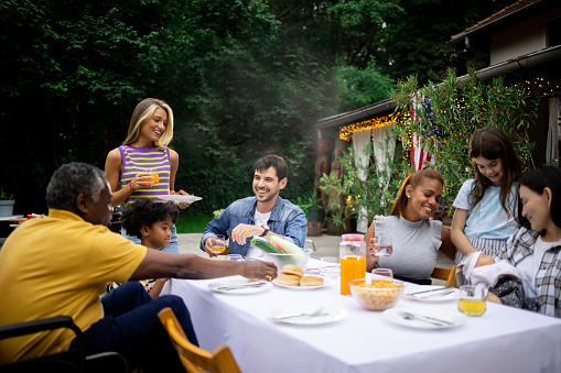 Family enjoys a happy family lunch in the backyard