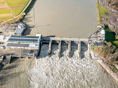 Aerial view of a small hydroelectric power plant located on the Sava river. After the storm, muddy water. Renewable energy is key to saving the environment.