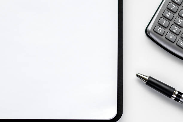 istock Business background with notepad, calculator and pen on a white background. 1882205077