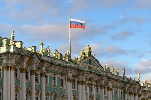 Winter Palace and Russian flag in Saint Petersburg, Russia.