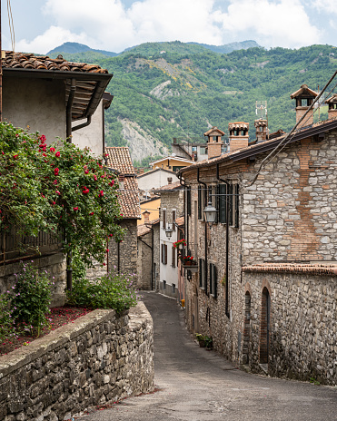An atmospheric shot of a narrow cobblestone alley in the historical town of Bobbio, Emilia-Romagna, Italy